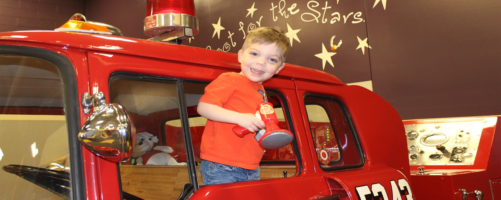 A young child enjoys a pretend fire engine