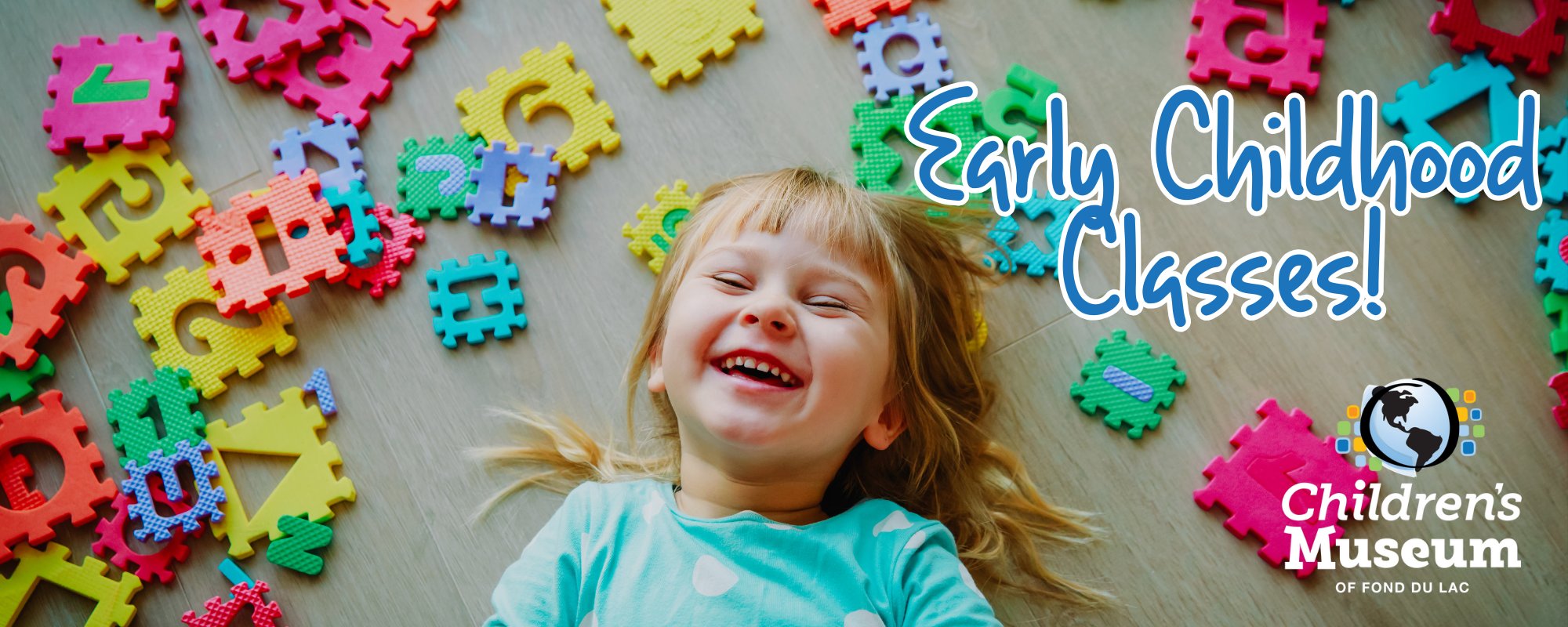 child laughing on the floor with toys